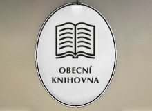 Smaltovaný ovál s piktogramem knihy a nápisem OBECNÍ/MĚSTSKÁ KNIHOVNA.