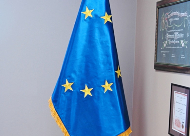 Slavnostní saténová vlajka Evropské unie vyvěšena na dvoudílné žerdi