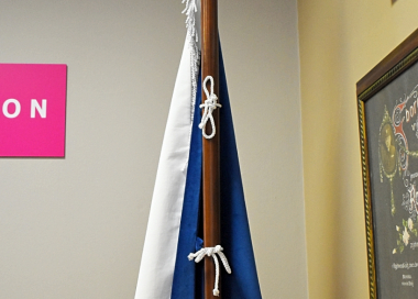 Ukázka uchycení vlajky ČR na jednodílné žerdi přes ozdobné kroucené šňůrky provlečené poutky všitými v praporu