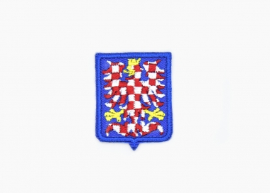 Rukávová nášivka - Moravská orlice na modrém poli ve tvaru štítu, motiv moravské orlice vyšitý na modrém podkladovém materiálu.