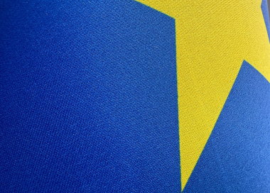 Detail dvouvrstvého textilního materiálu s integrovanou blockout vrstvou zajišťující neprůsvitnost vlajky.